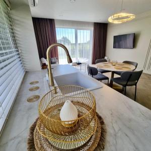 a kitchen with a sink and a counter top with a basket at Makin' Memories - Apartamentai Monciškėse in Palanga