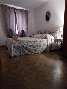Casa Profumo d' Estate في بيتيجليانو: غرفة نوم بسرير ونافذة مع ستائر