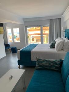 Habitación de hotel con 2 camas y sofá en Ocean Blue Suites, en Ierissos