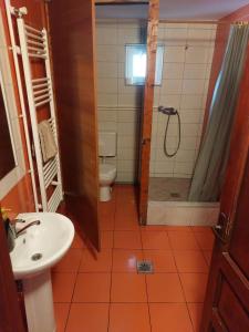 a bathroom with a toilet and a shower and a sink at Camping Cabana Gonduzo in Vălenii de Mureş