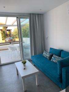 a living room with a blue couch and a table at Ocean Blue Suites in Ierissos