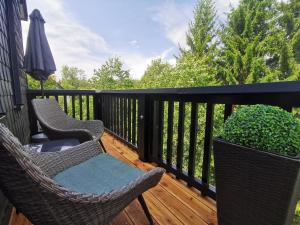 a balcony with two chairs and an umbrella at country-suites by verdino LIVING - Apartments & Suites in Braunlage