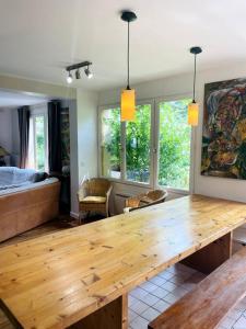 ein Wohnzimmer mit einem Holztisch und einem Bett in der Unterkunft La Cour Des Jardins in Neufmoutiers-en-Brie