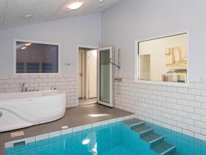 a bathroom with a tub and a swimming pool at 16 person holiday home in Alling bro in Rygård Strand