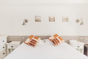 - une chambre avec un lit blanc et des oreillers dans l'établissement Hôtel Édenia - Spa Estime&Sens, à Carnac