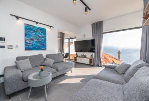 a living room with two couches and a view of the ocean at Villa Sanja in Postira