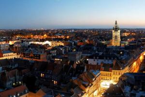 een uitzicht op een stad in de nacht met een klokkentoren bij * Le Cocon * Centre-ville Douai-500m place d'Armes in Douai