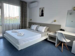 a bedroom with a bed with a desk and a chair at Satmar in Lozenets