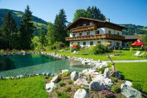 una casa con un estanque delante de un edificio en Lehenriedl Appartements, en Wagrain