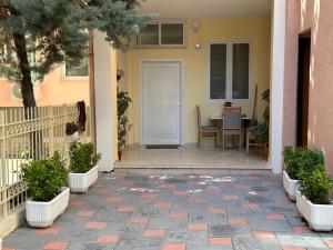 a porch of a house with a table and a white door at Villa Apartments S&F City Centre in Tirana