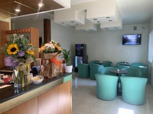 ein Wartezimmer mit blauen Stühlen und einem Tresen mit Blumen in der Unterkunft Hotel Al Capitano in Caorle