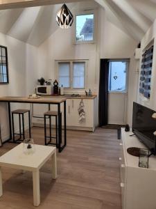 uma sala de estar com uma cozinha com uma mesa em Agréable studio avec cour à 10mn de Fontainebleau em Héricy