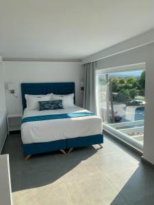 a bedroom with a bed and a large window at Ocean Blue Suites in Ierissos