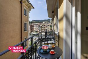 Riviera Flavour Apartments I by Wonderful Italy في سانتا مارغريتا ليغور: شرفة مع طاولة عليها طعام