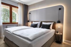 a large white bed in a room with a window at June Stay Lake Garda in Brenzone sul Garda
