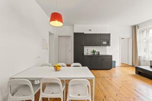cocina y comedor con mesa blanca y sillas en Apartments elPilar Friedrichshain, en Berlín