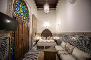 1 dormitorio con 2 camas y vidriera en Riad Sidrat Fes en Fez
