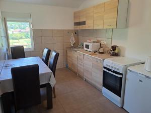 a small kitchen with a table and a microwave at Apartments Mirković in Cetinje