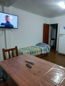 a room with a table and a bed and a television at Departamento Plaza España in San Rafael