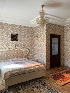 a bedroom with a bed and a chandelier at Тумар in Osh