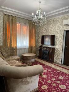 a living room with a couch and a chandelier at Тумар in Osh