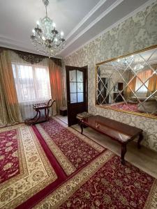 a living room with a large rug and a large mirror at Тумар in Osh