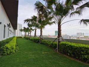 a walkway with palm trees on the side of a building at Melaka Town/Sea View/10 min to Jonker/4-6Pax(2015) in Melaka