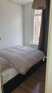 a bed in a room with a window at Amsterdam - Bright, canal-side, central, renovated 1BR in Amsterdam