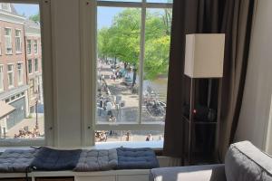 a living room with a couch and a large window at Amsterdam - Bright, canal-side, central, renovated 1BR in Amsterdam