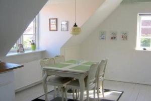 a dining room with a table and chairs at Skøn lejlighed i Ærøskøbing. in Ærøskøbing