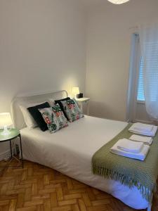 a bedroom with a large bed with pillows on it at Alvalade II Airport Guest House in Lisbon