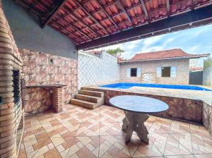 patio ze stołem i basenem w obiekcie Casa c piscina a 260m da Praia Itaoca Mongagua SP w mieście Mongaguá
