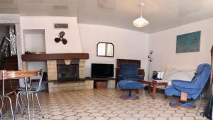 a living room with blue chairs and a fireplace at Maison 90 m2, 5 min du Port, 15 min des Criques à Pied in Port-Vendres