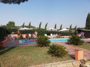 een groep mensen die rond een zwembad zitten bij Casale Monte Amato in Tornasano