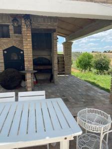 a picnic table and chairs on a patio with a fireplace at Casale Monte Amato in Tornasano