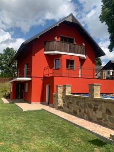 a red house with a balcony on top of it at Apartmán u Drahotů in Pernink