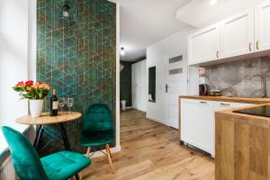 een keuken met een tafel en groene stoelen in een kamer bij Pańska Residence in Gdańsk