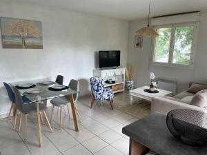 uma sala de estar com um sofá, uma mesa e cadeiras em Appartement T3, Terrasse, Piscine, 2 Places Parking Privé em Onet le Château