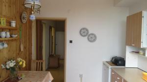 kuchnia ze stołem i zegarami na ścianie w obiekcie BEST MOUNTAIN VIEIW APARTMENT w Szczyrbskim Plesie