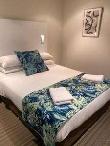 a bed with two towels on top of it at Liberty bay holiday Spacious two bedroom, two bathroom with sea views in Glenelg