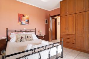 a bedroom with a large bed and a wooden cabinet at Lakis Apartment in Meganisi