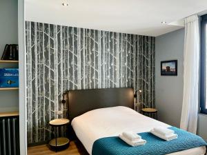 a bedroom with a bed with two towels on it at Le Five Tellier - Forest in Reims +5 photos