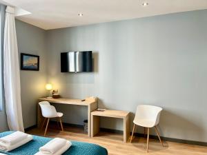 a room with a desk and two white chairs at Le Five Tellier - Forest in Reims
