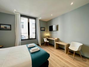 a bedroom with a bed and a desk and a window at Le Five Tellier - Forest in Reims