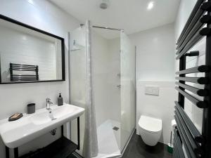a white bathroom with a sink and a toilet at Le Five Tellier - Forest in Reims