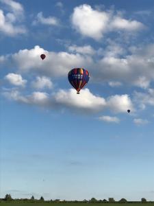 three hot air balloons flying in the sky at Le Moulin de Francueil in Francueil