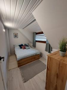 een slaapkamer met een bed in een kamer met een plafond bij Master Camp Santoczno in Santoczno