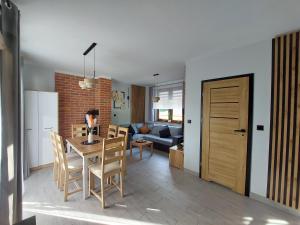 een keuken en een woonkamer met een tafel en stoelen bij Master Camp Santoczno in Santoczno