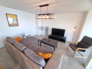 ein Wohnzimmer mit einem Sofa und einem TV in der Unterkunft Villa La Turbie Vue Panoramique in La Turbie
