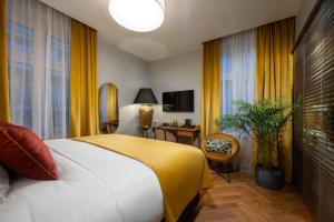 a hotel room with a bed and a desk and window at Sava Boutique Hotel in Warsaw